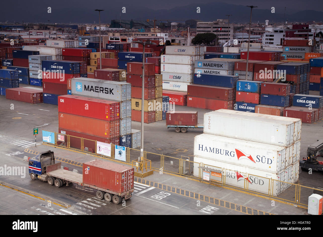 A lorry passing in front of Shipping Containers stacked in the Container Port of Callao, Peru. Stock Photo