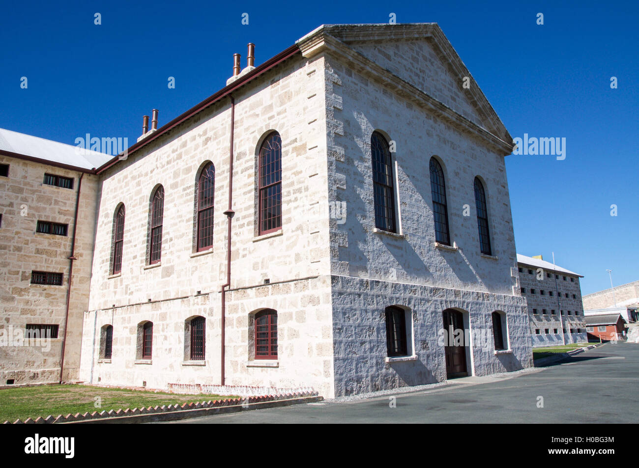 Exterior of the old limestone Fremantle Prison with limestone brick and arched windows in