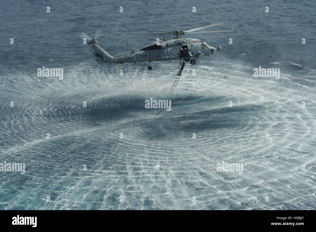 U.S. Navy special forces EOD commandos during a ladder recovery exercise at sea from an HH-60H Seahawk helicopter September 22, 2012 in the Arabian Sea. Stock Photo