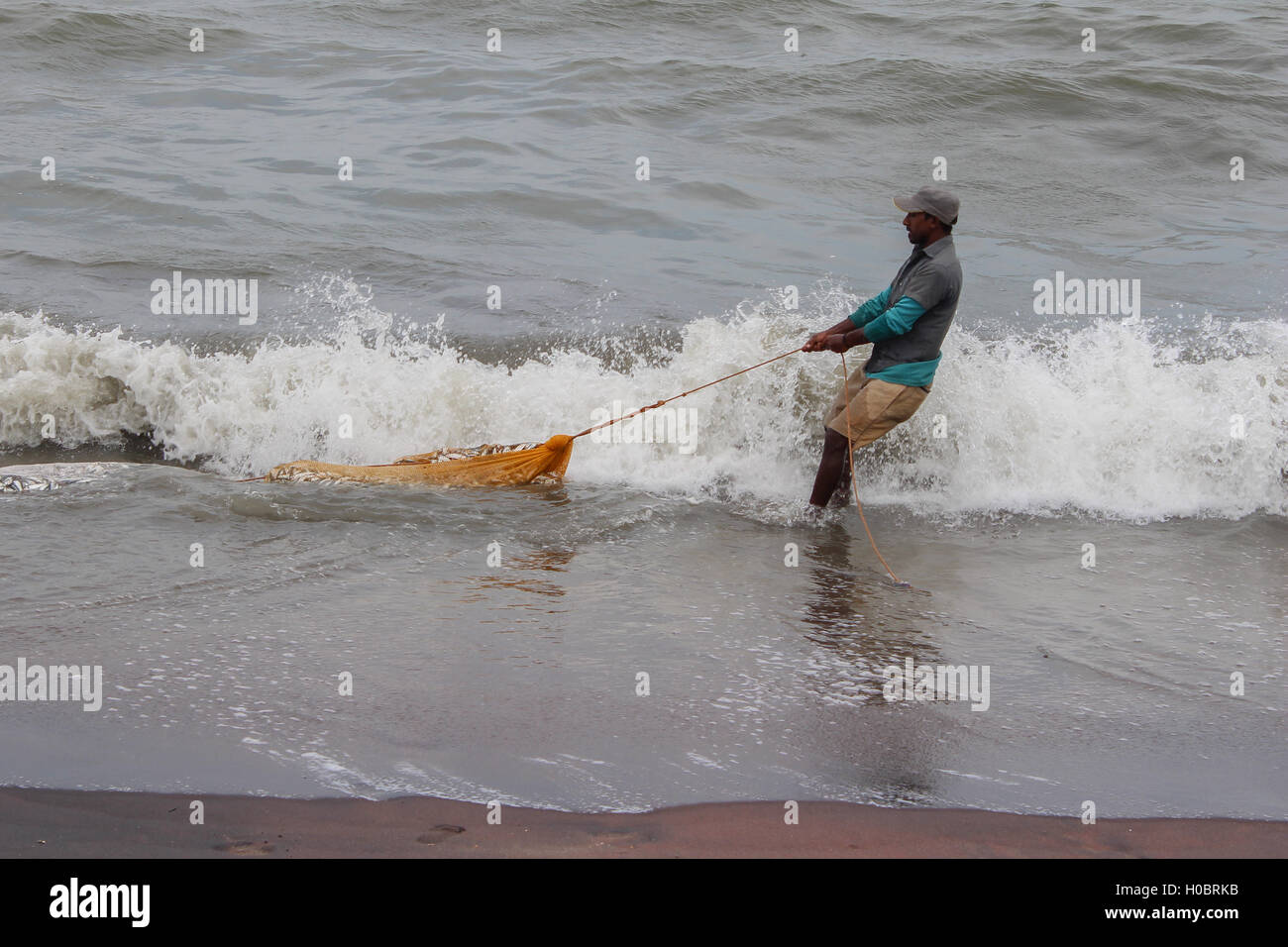 Sri Lanka Fisherman pulling net with fish Stock Photo