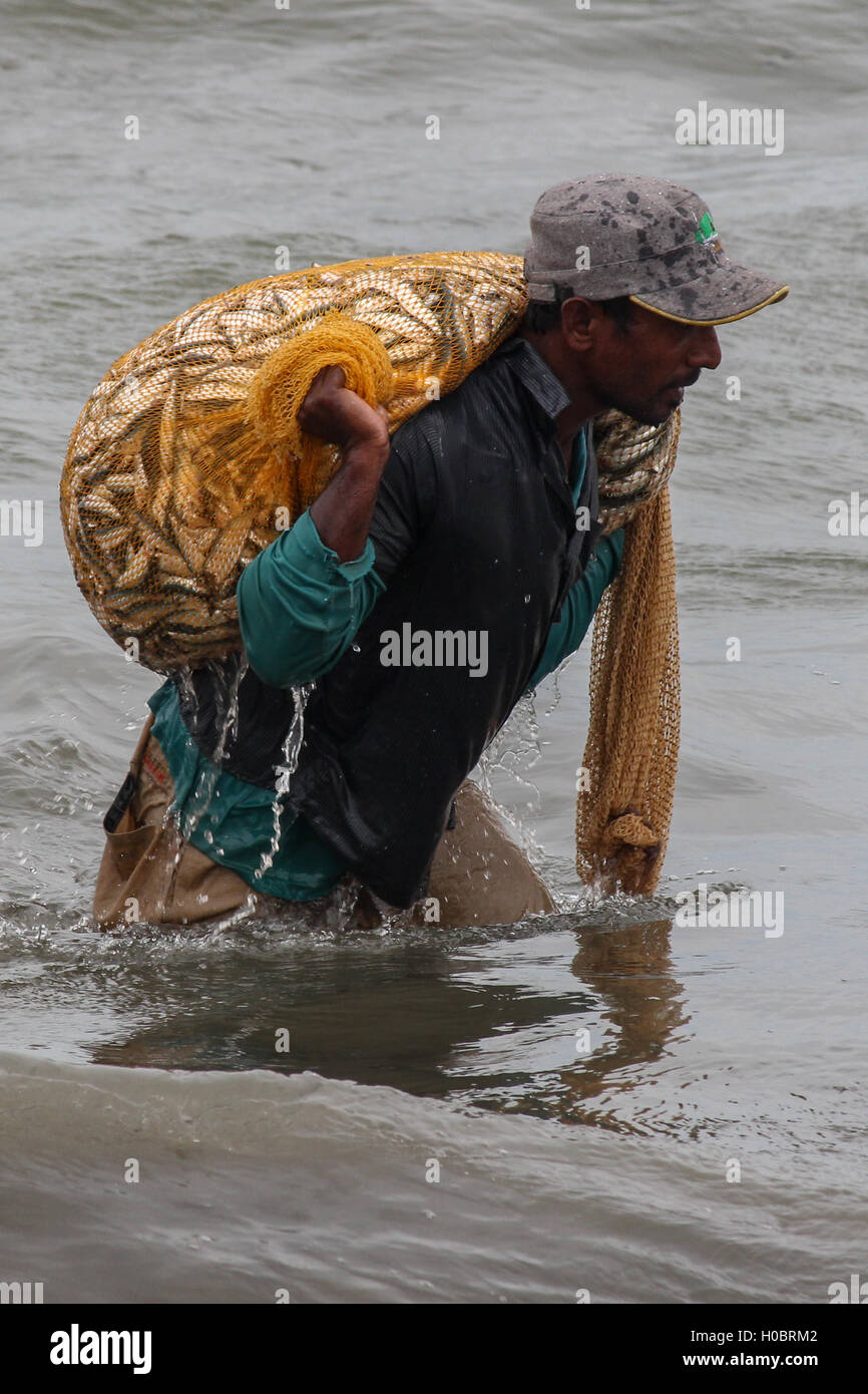 Portrait of a fisherman carrying fish in a cast net Stock Photo