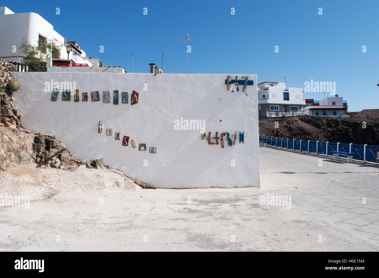 Fuerteventura: the words Hope, Illusion, Peace and Cheerfulness composed in Spanish by pieces of old boats on white wall in the village of El Cotillo Stock Photo