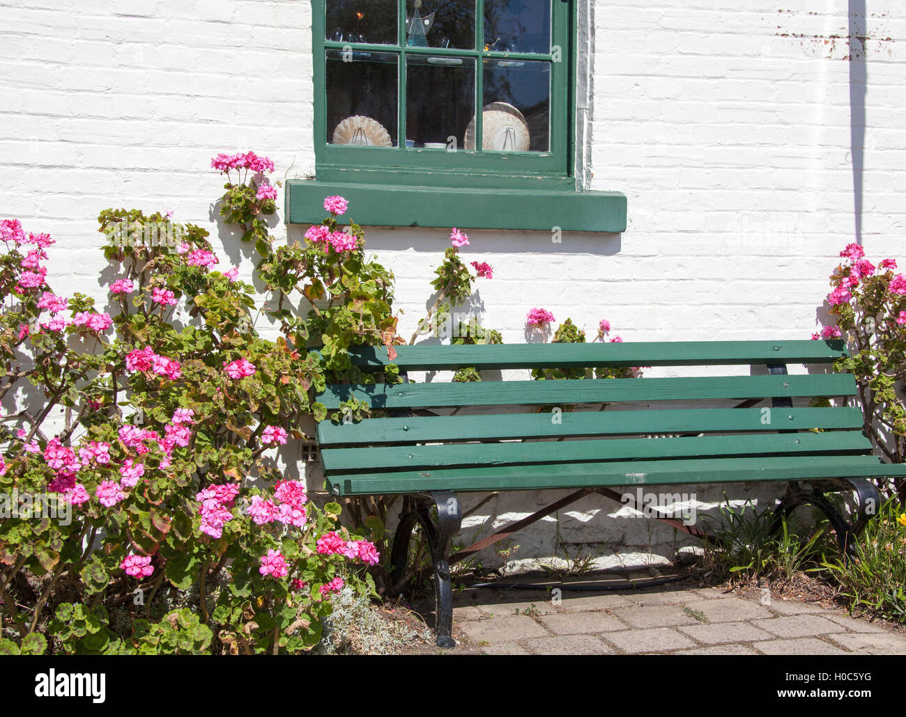 The little bench surrounded by flowers on a main street of historic Richmond town (Tasmania). Stock Photo