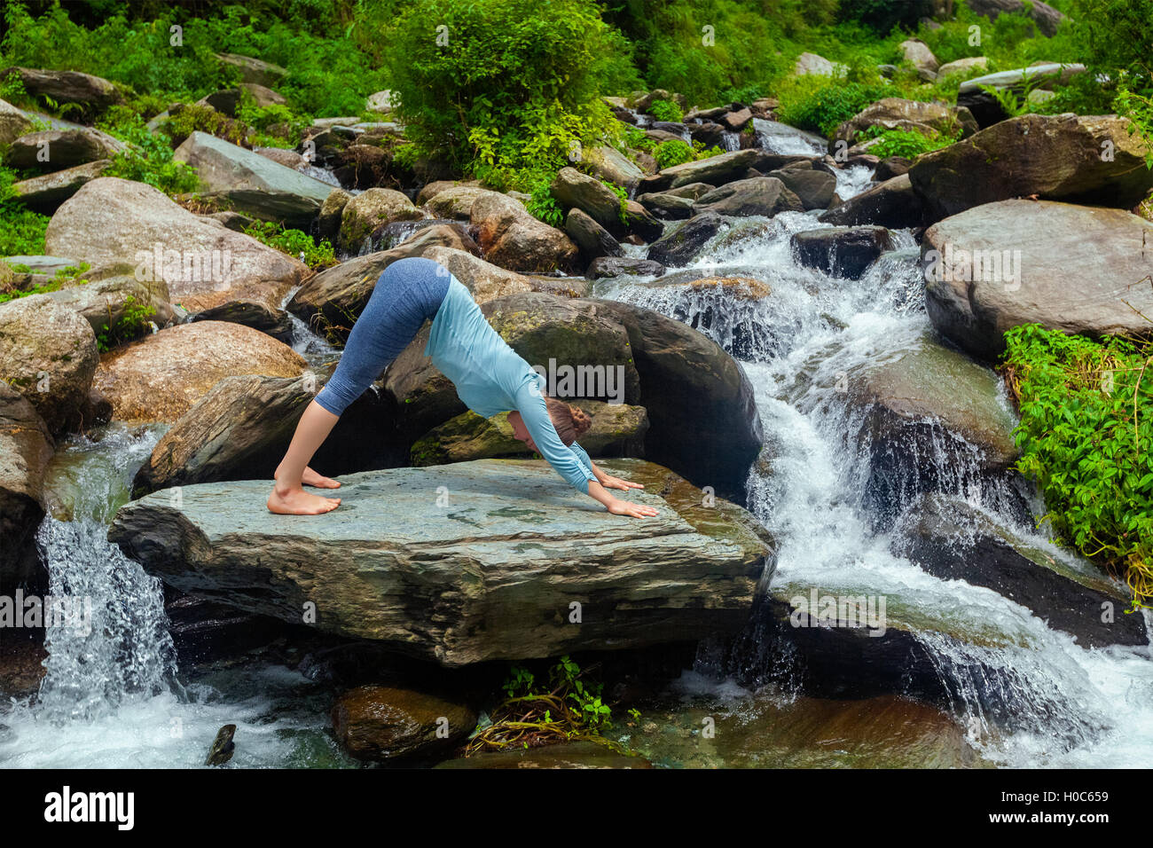Young sporty fit woman doing yoga oudoors at tropical waterfall Stock ...