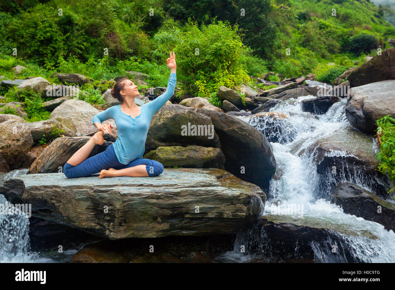 Sorty fit woman doing yoga asana outdoors at tropical waterfall Stock ...