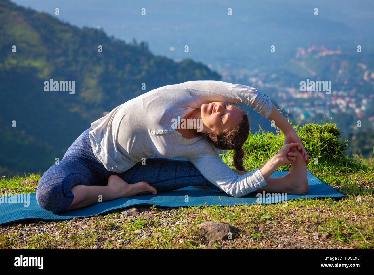 Young sporty fit woman doing Yoga asana parivritta janu sirsasana Stock Photo