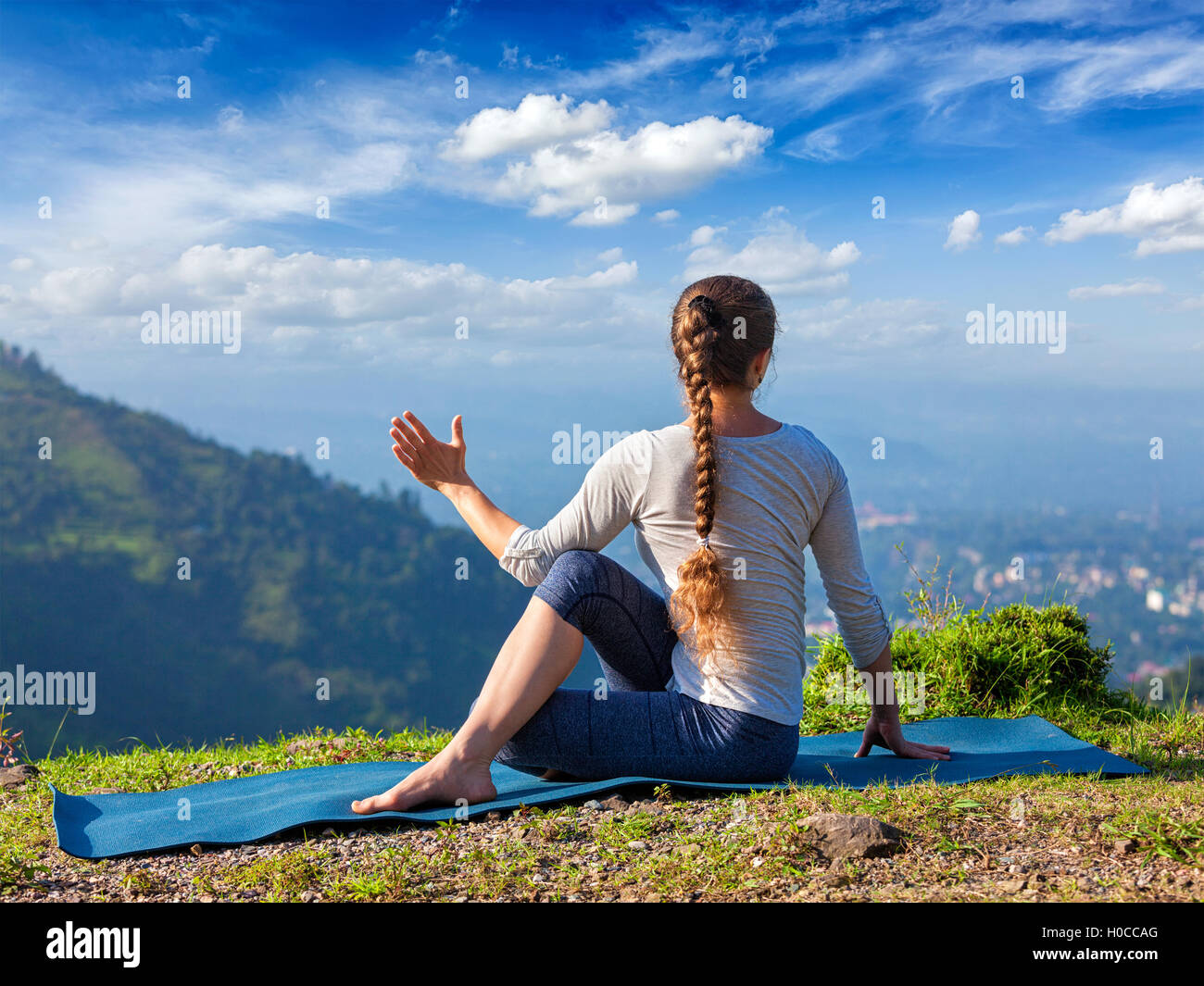 Woman practices yoga asana outdoors Stock Photo