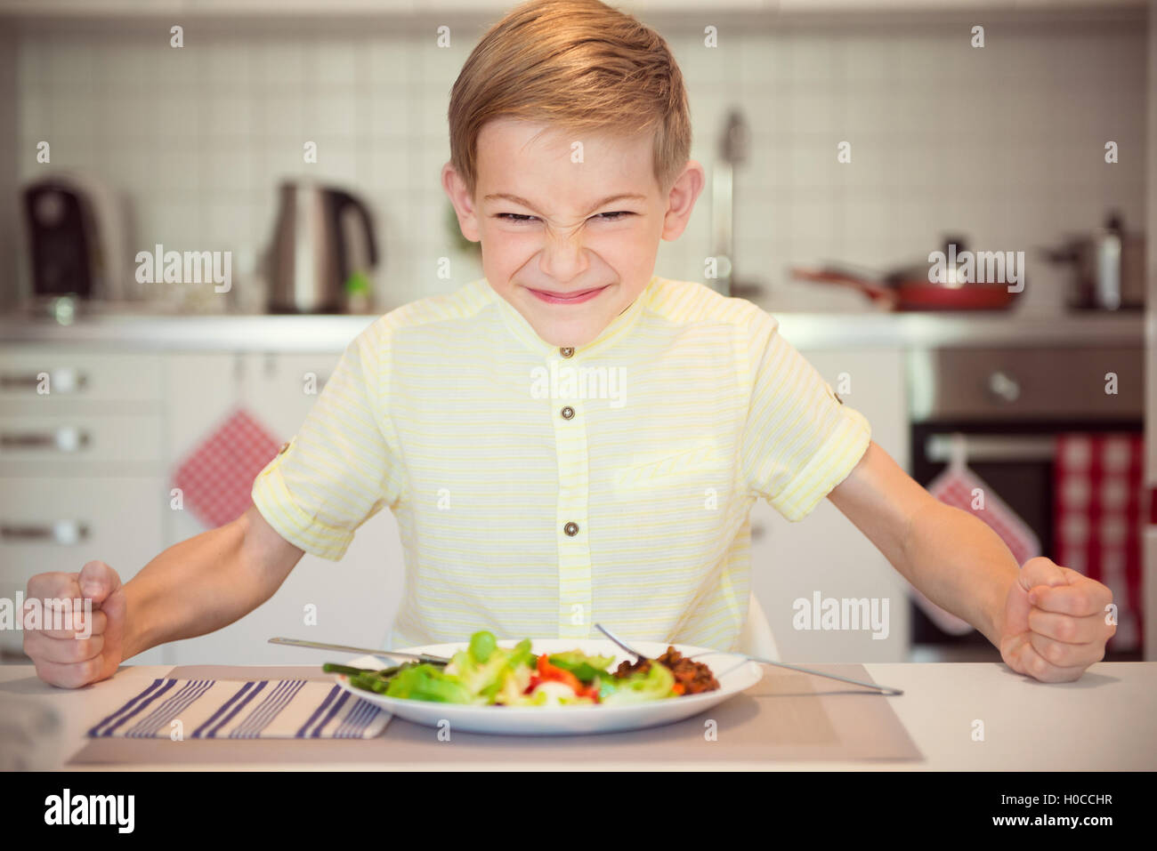 Angry hungry boy child banging his fist on the table Stock Photo