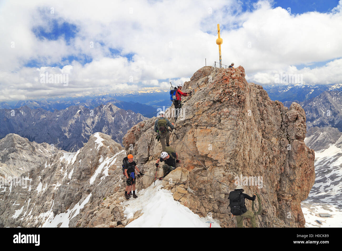 Climbers at the cross on the summit of Zugspitze Mountain, the highest in Germany Stock Photo