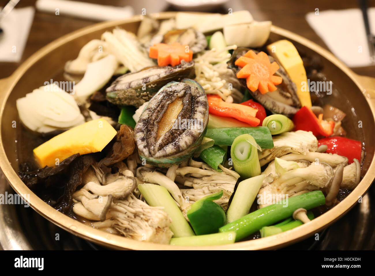 Abalone hot pot called the nobility of the sea with mushroom, pumpkin, carrot and herbs Stock Photo