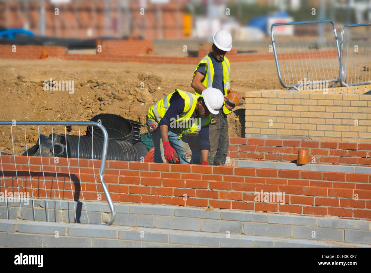 Two Construction workers laying the drains in a new house Stock Photo