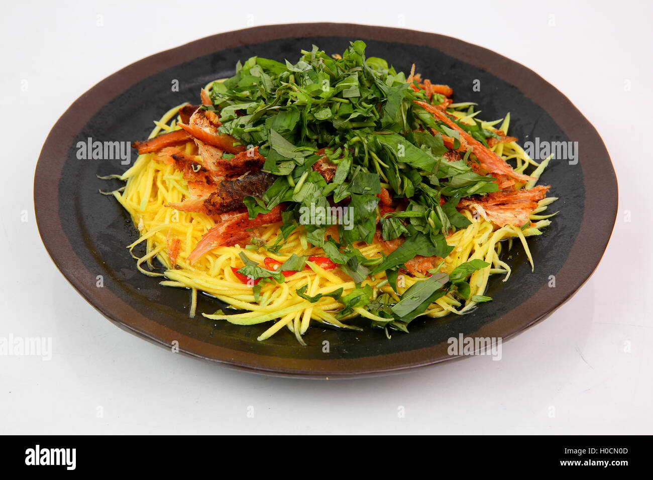 Mango salad with dried minced snake head fish in Mekong style on black ...