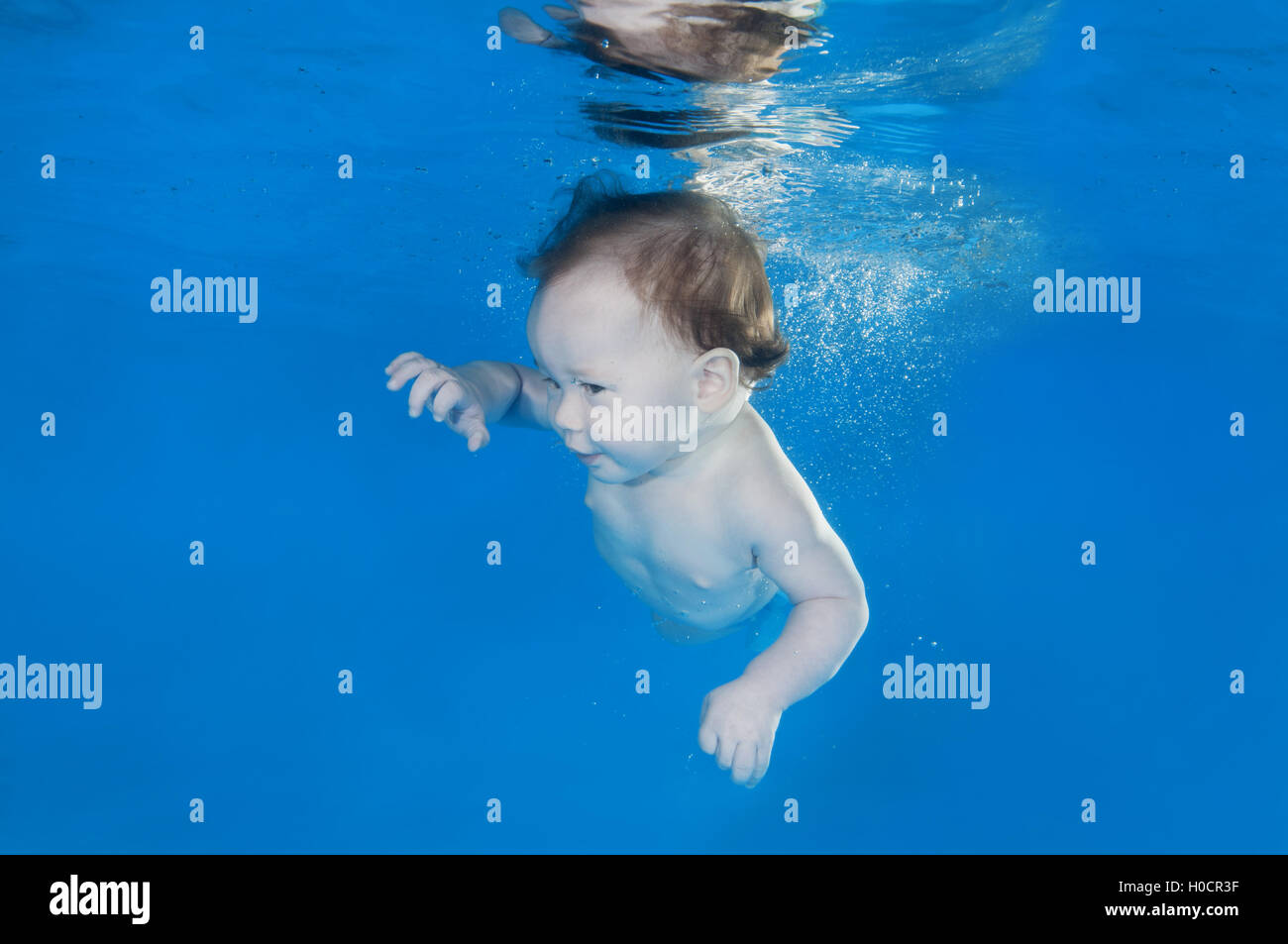 5 months infant boy learning to swim underwater in waterbaby class in