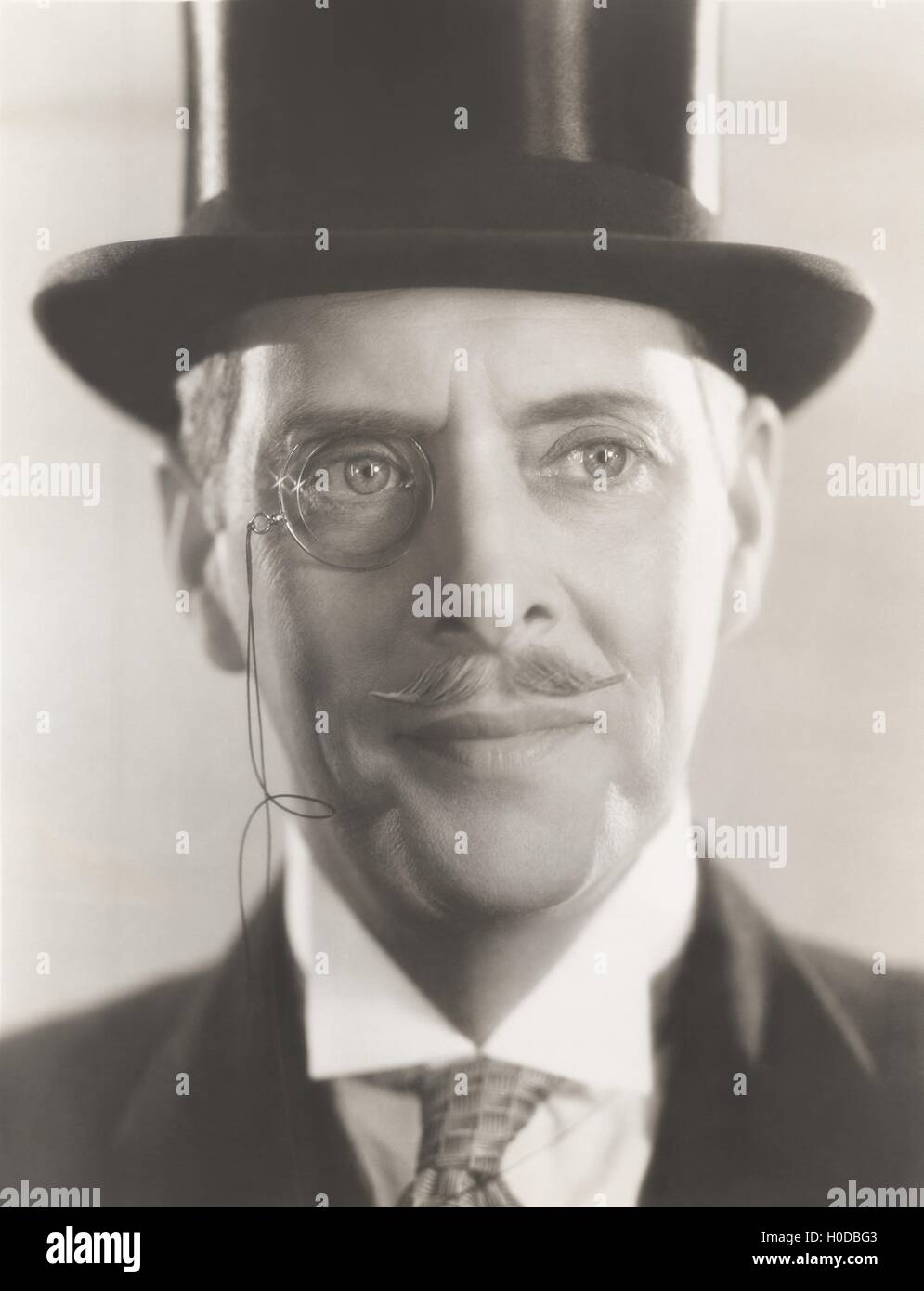 Portrait of man wearing monocle and top hat Stock Photo