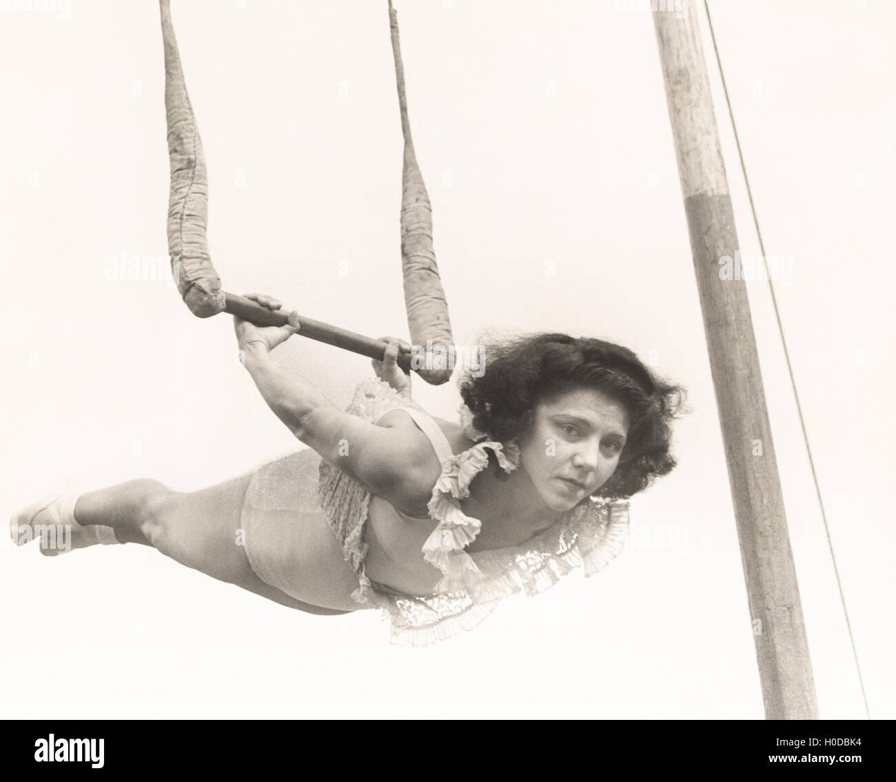 Female trapeze artist in mid-air Stock Photo