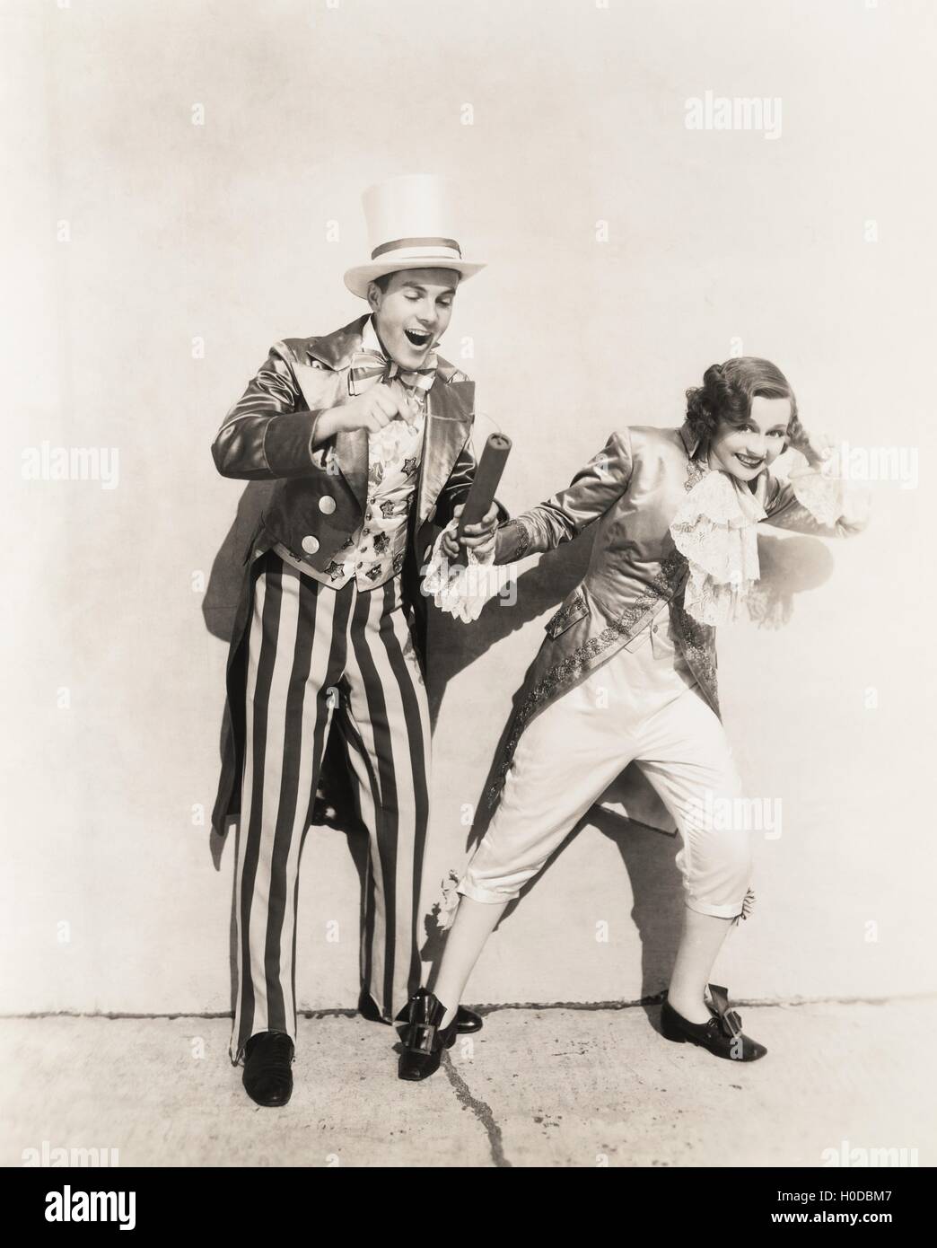 Two people in 18th century costumes playing with firecrackers Stock Photo