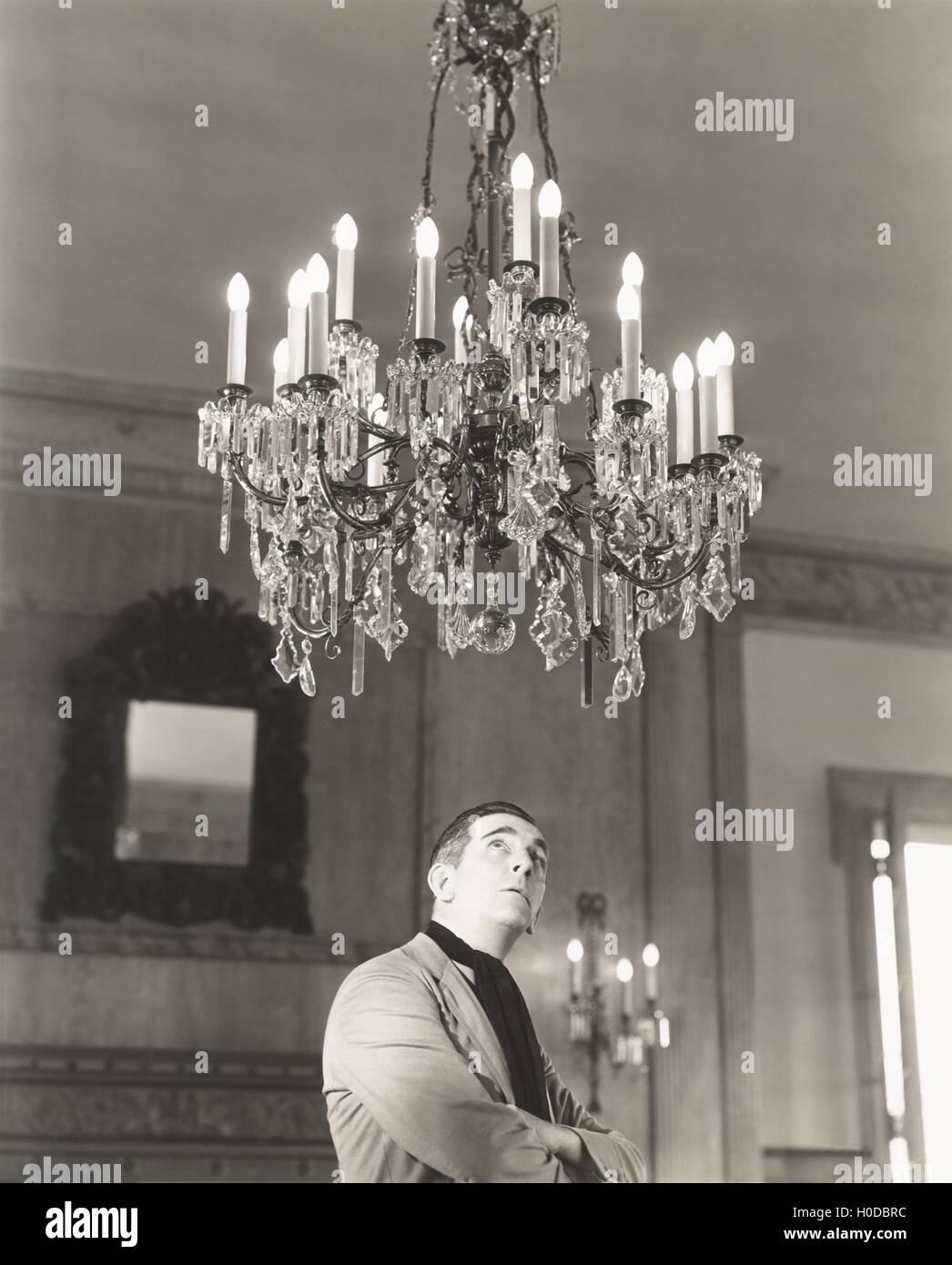 Man staring at chandelier Stock Photo