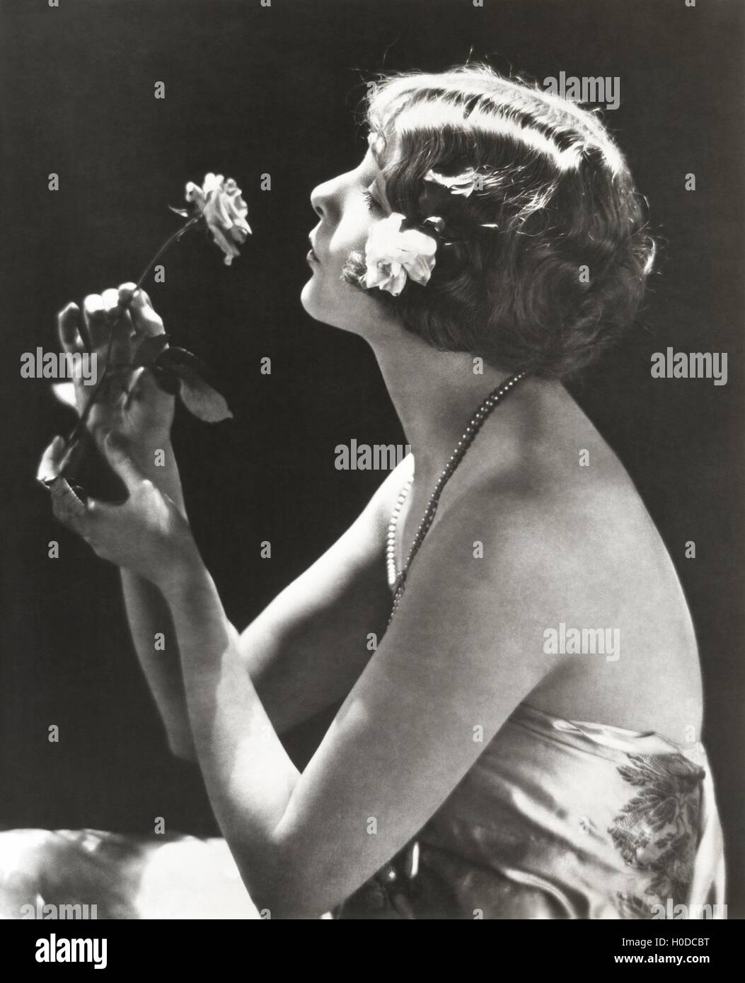 Profile view of young woman smelling flower Stock Photo
