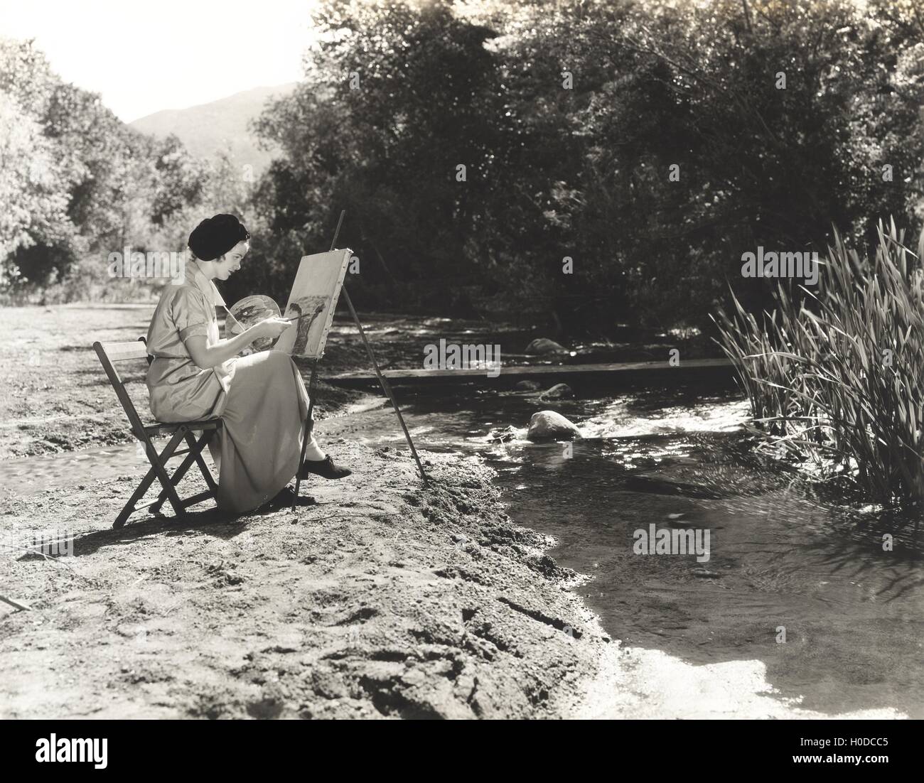 Portrait of a female artist painting by the river Stock Photo - Alamy