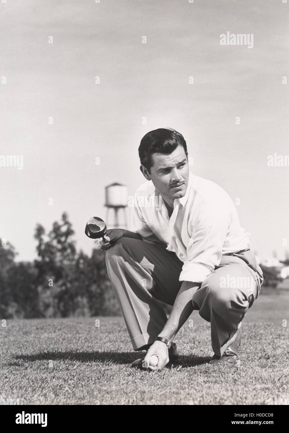 Golfer crouching on golf course Stock Photo