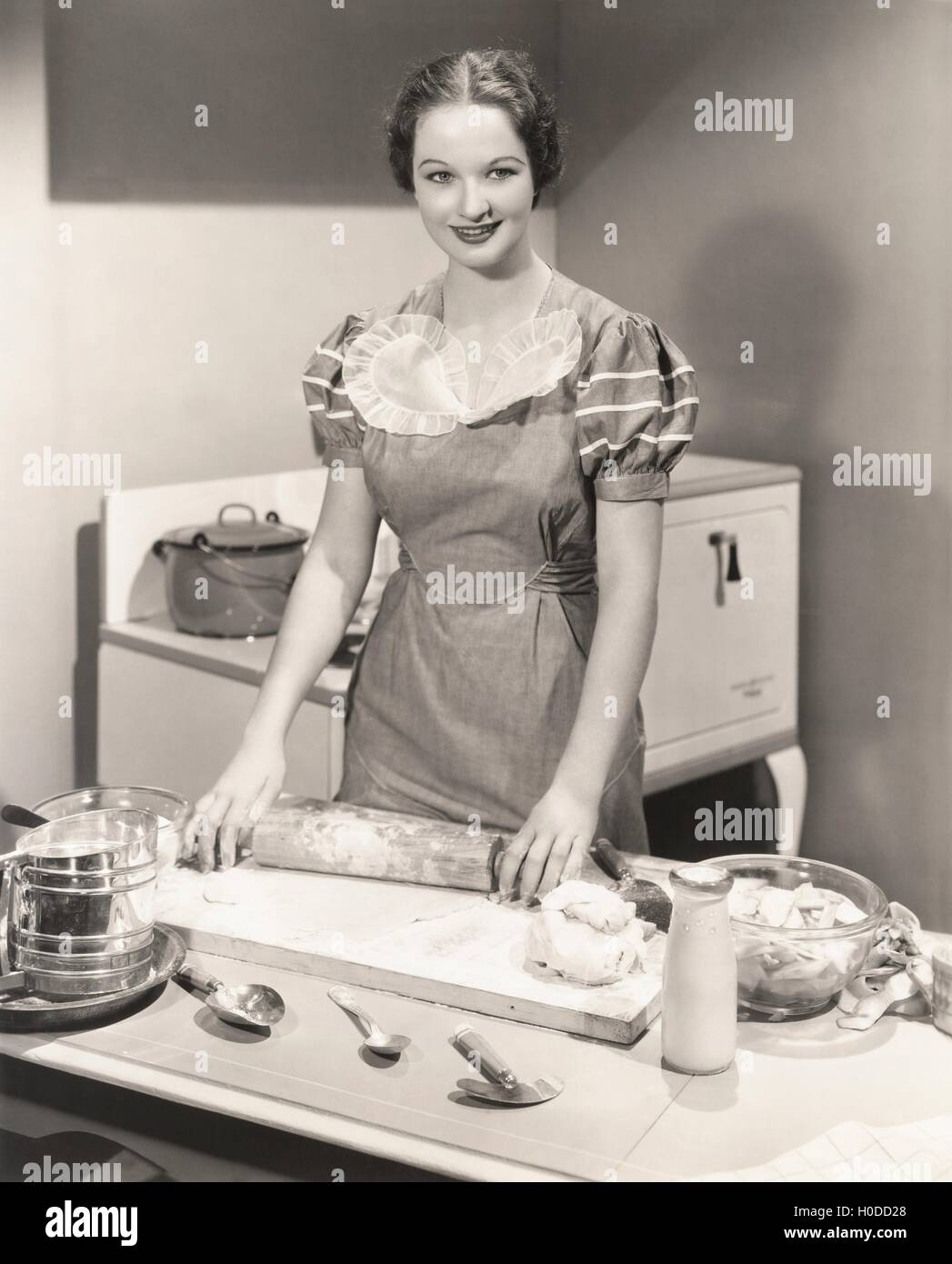 Woman rolling dough on kitchen counter Stock Photo