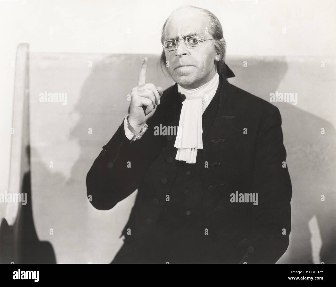 Man in square wire rim glasses making a point Stock Photo