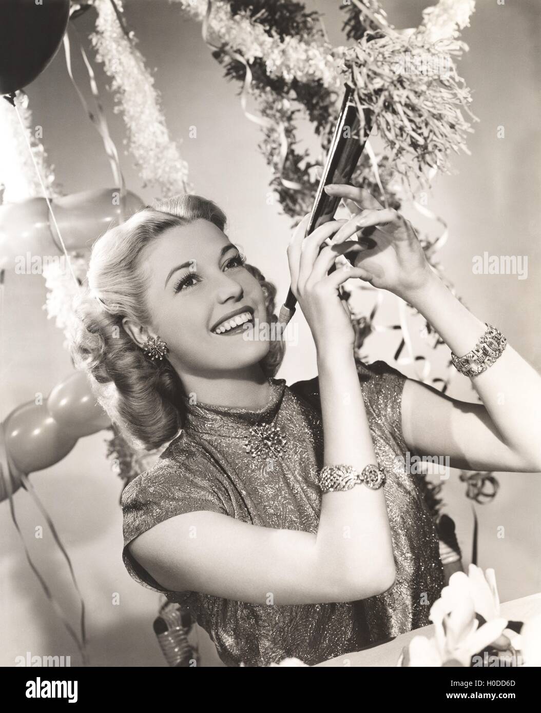 Woman holding party favor Stock Photo - Alamy