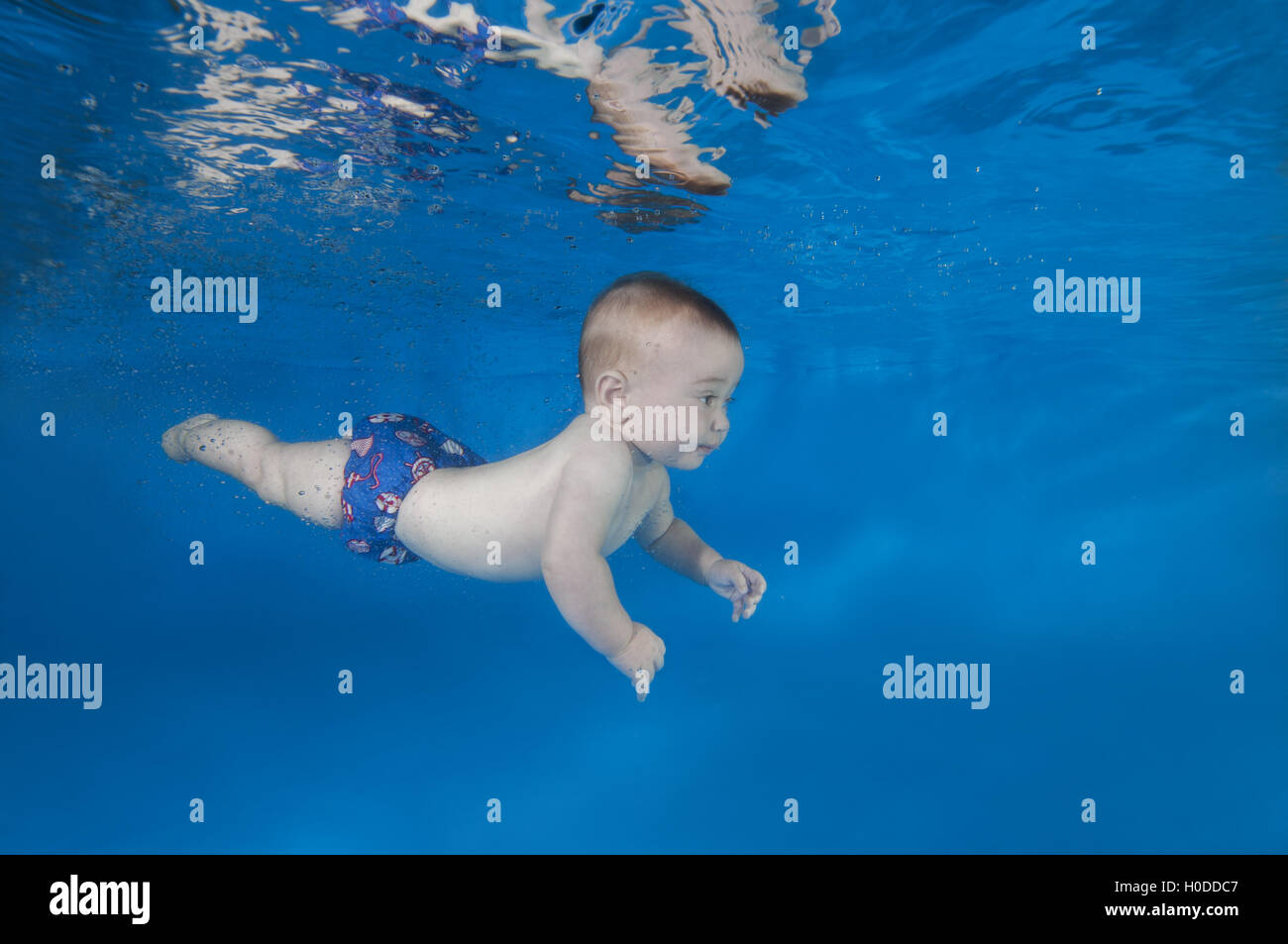 6 months infant boy learning to swim underwater in waterbaby class in