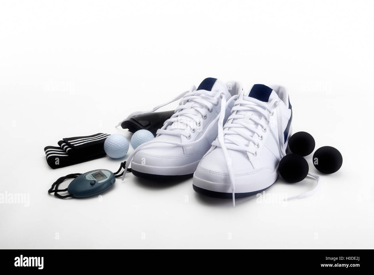 Sports shoes and various training/exercise items,including trainers, squash balls, stopwatch, golf balls, wrist bands Stock Photo