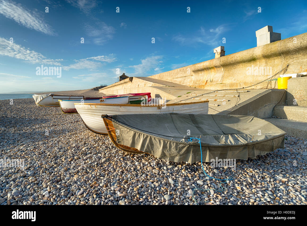 Fishing boats under a blue sky at Chesil Cove on the Portland end of