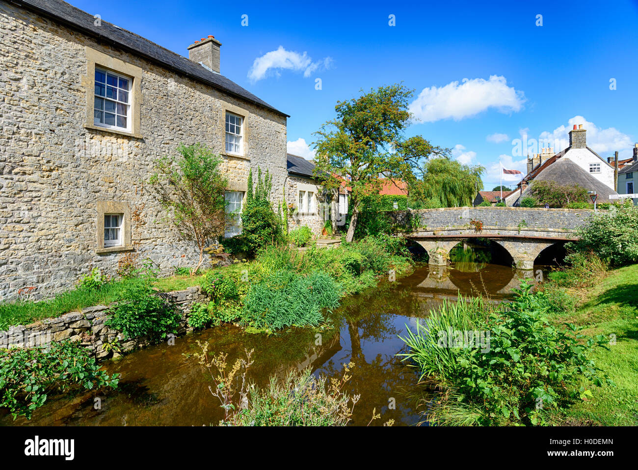 Pretty cottages and a bridge over the river at Nunney in Somerset Stock Photo