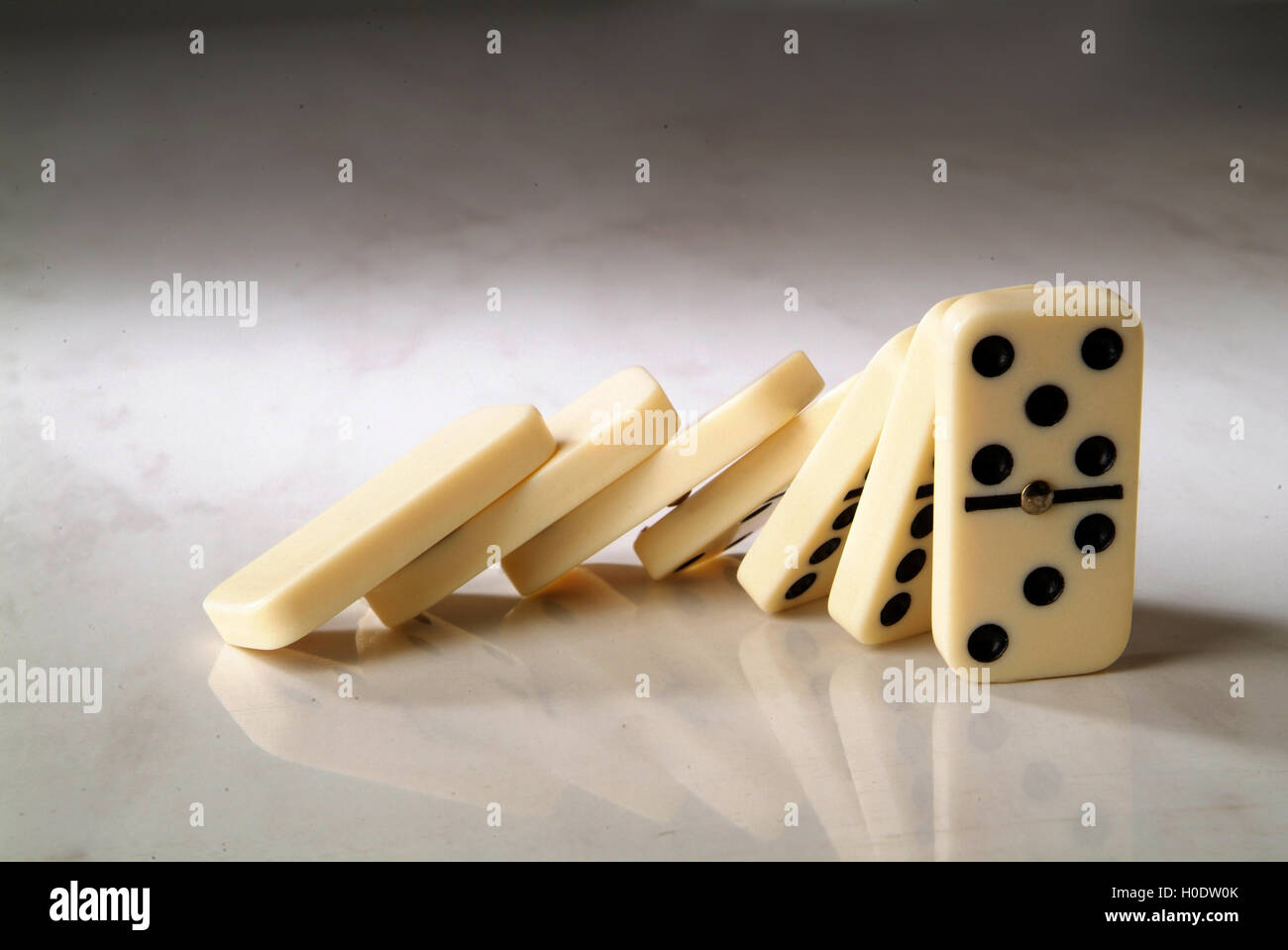 group dominoes fall on a neutral background Stock Photo - Alamy