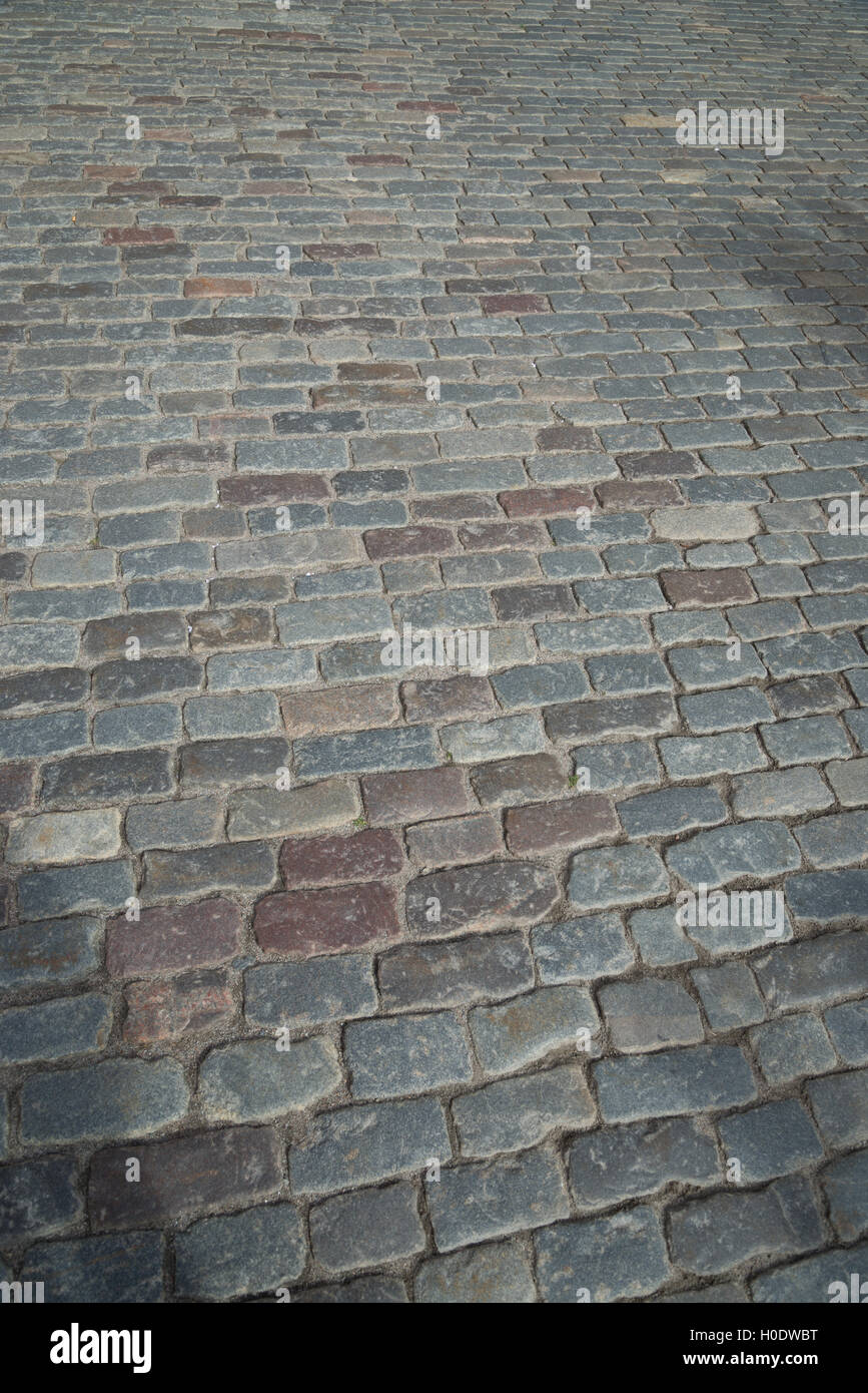 Cobble stones in a cobbled street. Granite sett stones placed in rows. Stock Photo