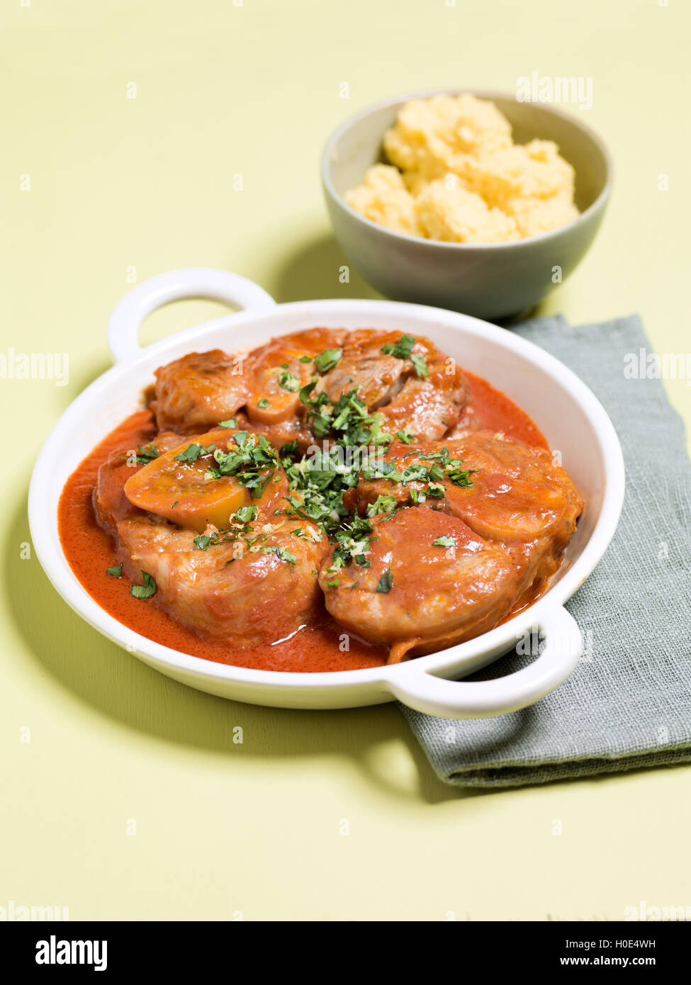 Osso buco con gremolata or Veal Shank Milanese on white plate in