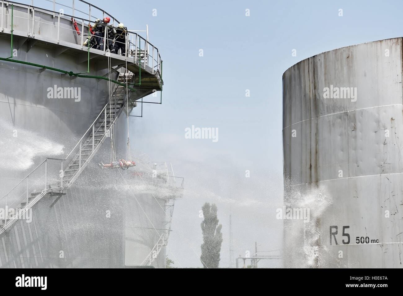 Firefighter water jet extinguish the fire started near a petrol storage tank Stock Photo Alamy
