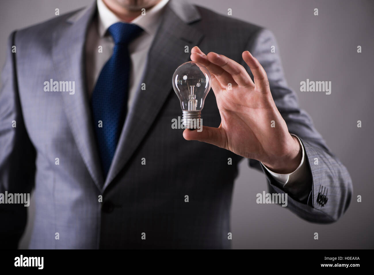 Businessman holding light bulb in creativity concept Stock Photo - Alamy