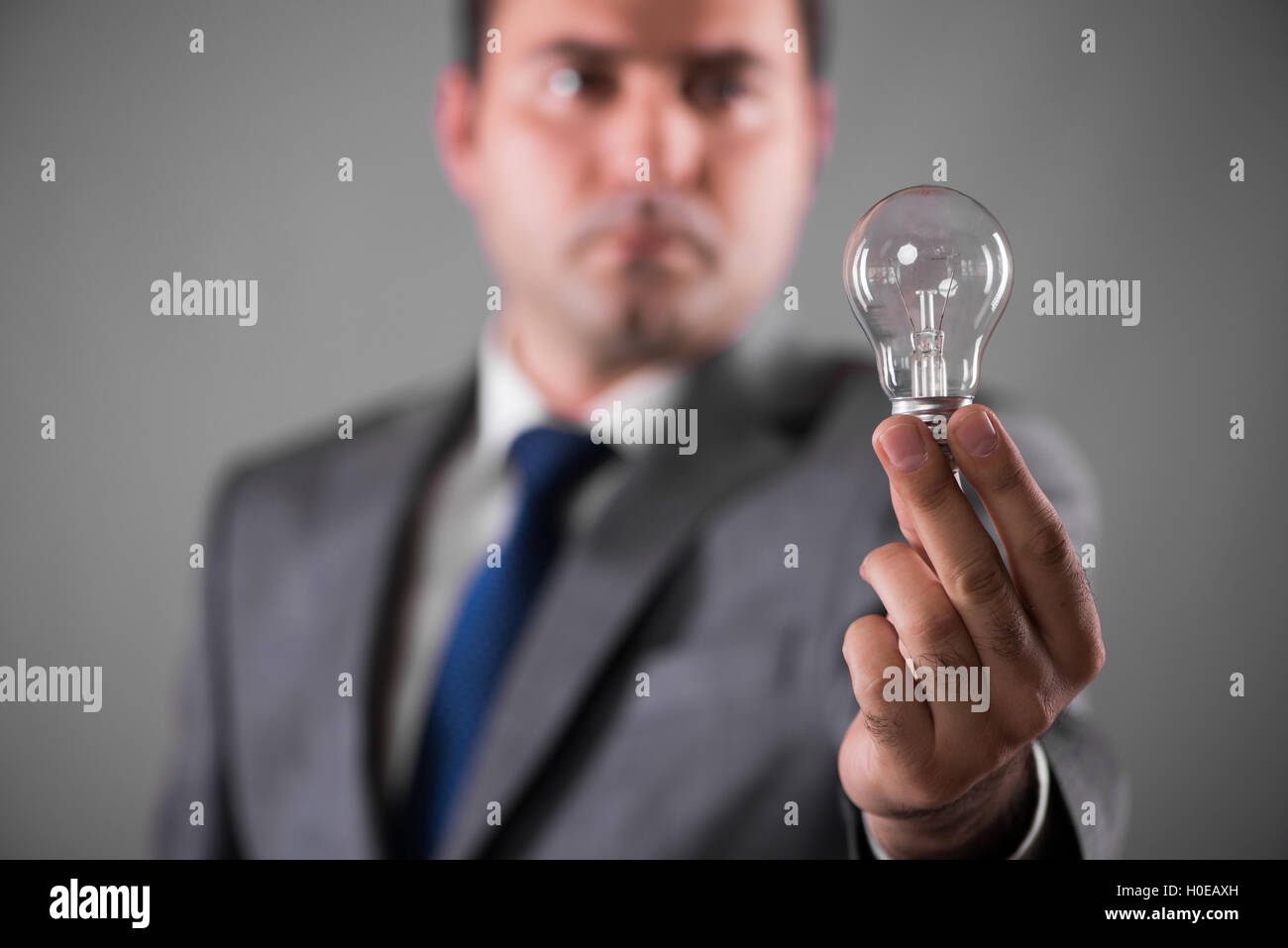 Businessman holding light bulb in creativity concept Stock Photo - Alamy
