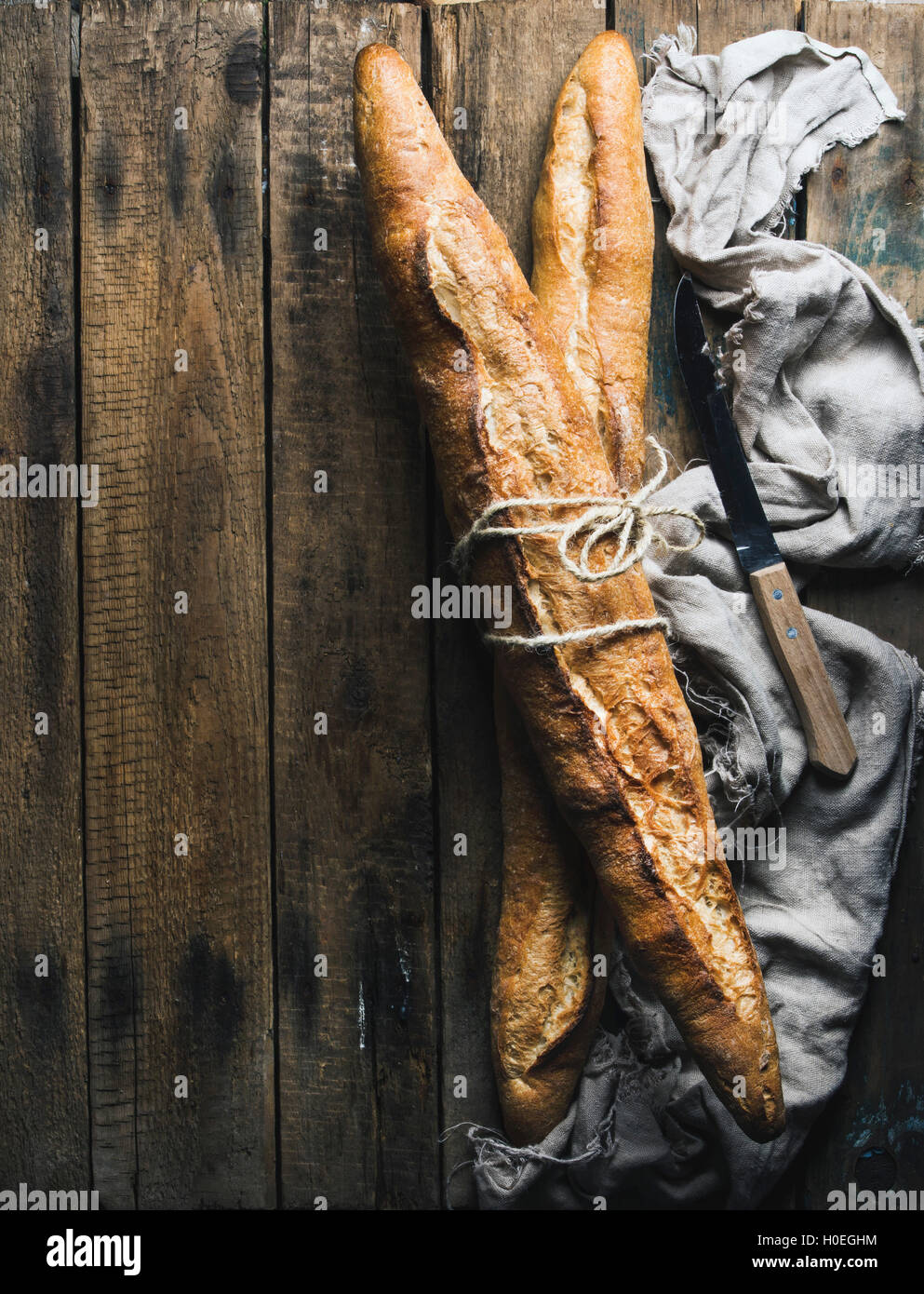 French baguettes on rough rustic wooden background. Top view, copy space Stock Photo
