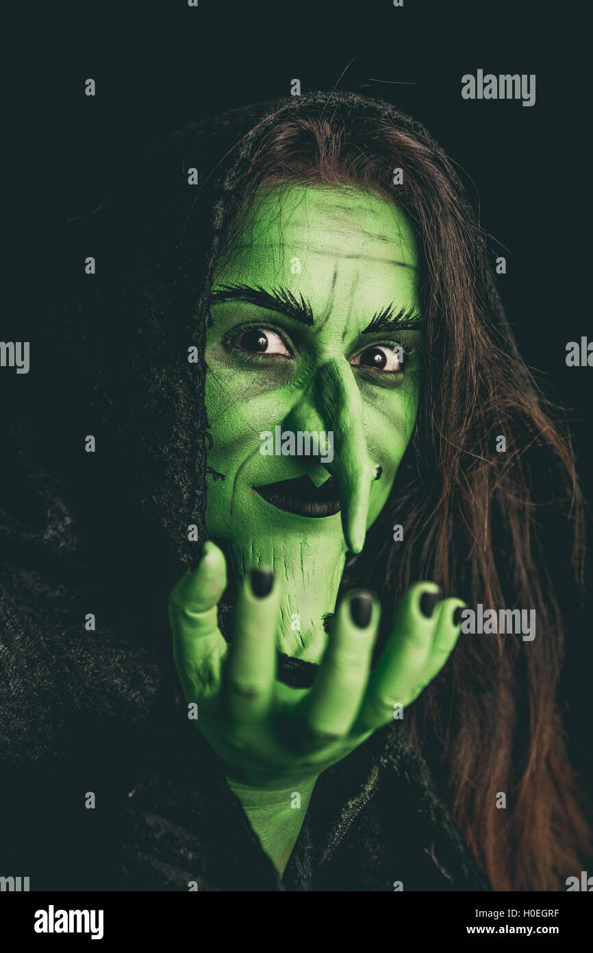 Green witch acting like she is holding something. Shallow depth of field. Stock Photo