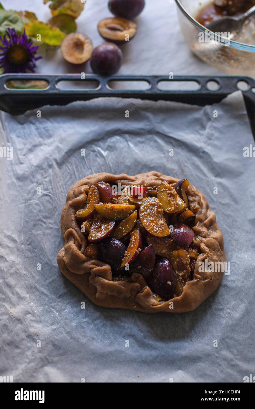 Plum galette on a baking tray before baking Stock Photo