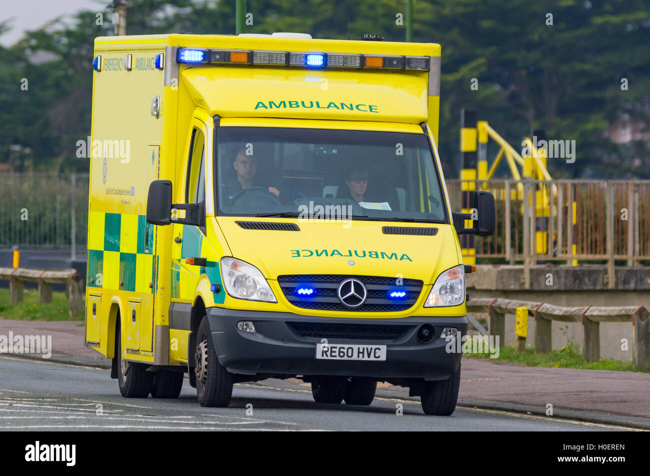 Ambulance with blue lights flashing on a road in the UK. NHS ambulance UK. Ambulance blue lights. Ambulance service. Mercedes Benz Sprinter from 2011. Stock Photo