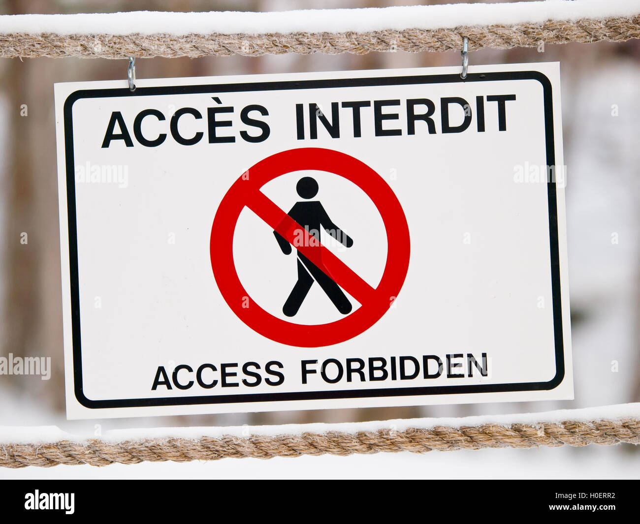 Bilingual access forbiden sign on rope in winter Stock Photo