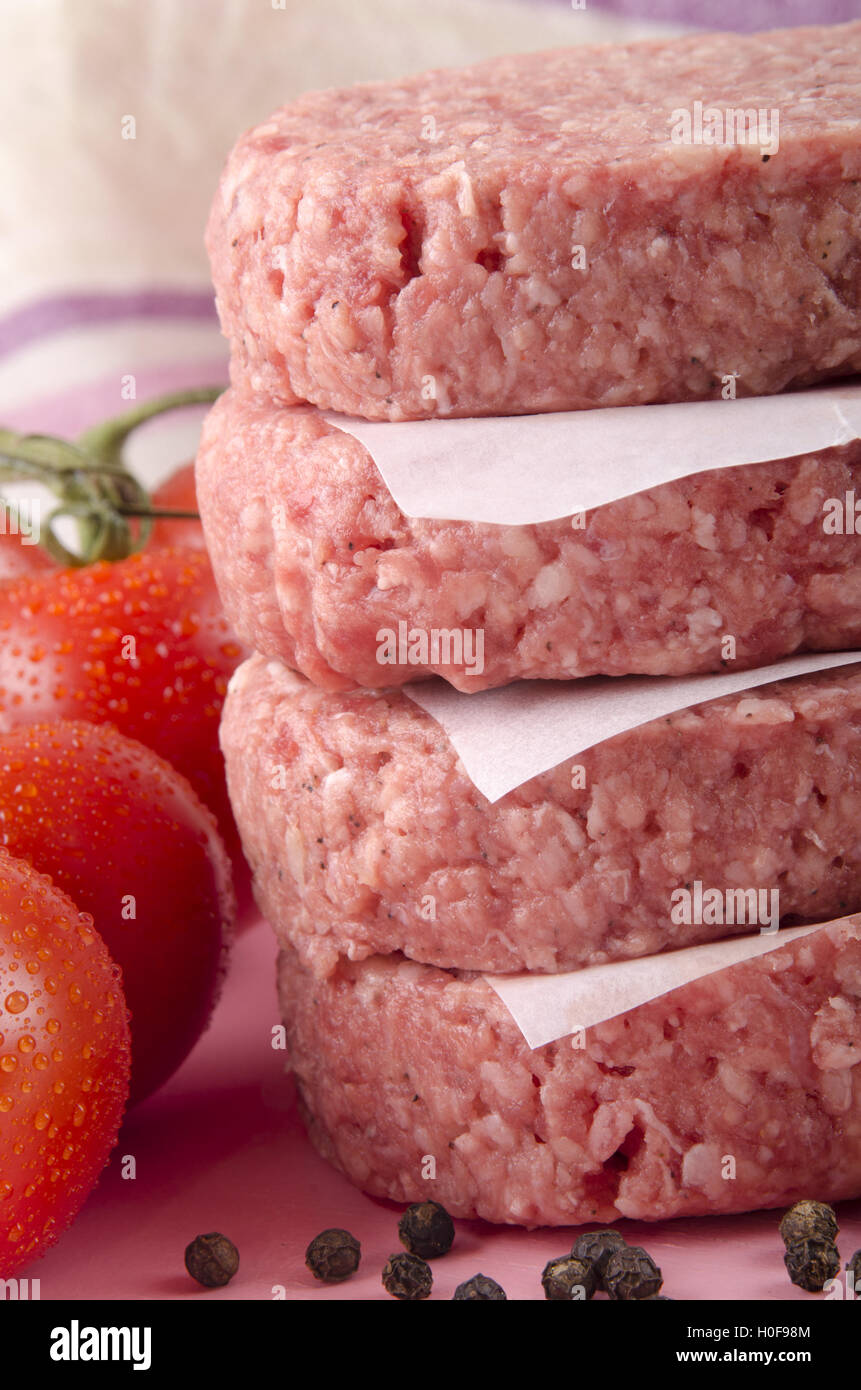 four raw hamburger and tomato Stock Photo Alamy