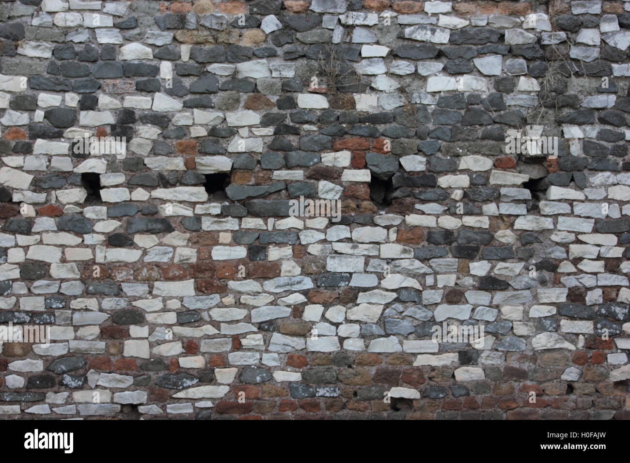 a coloured antique stone brick wall, Rome, Roma, pattern, texture, repetition Stock Photo