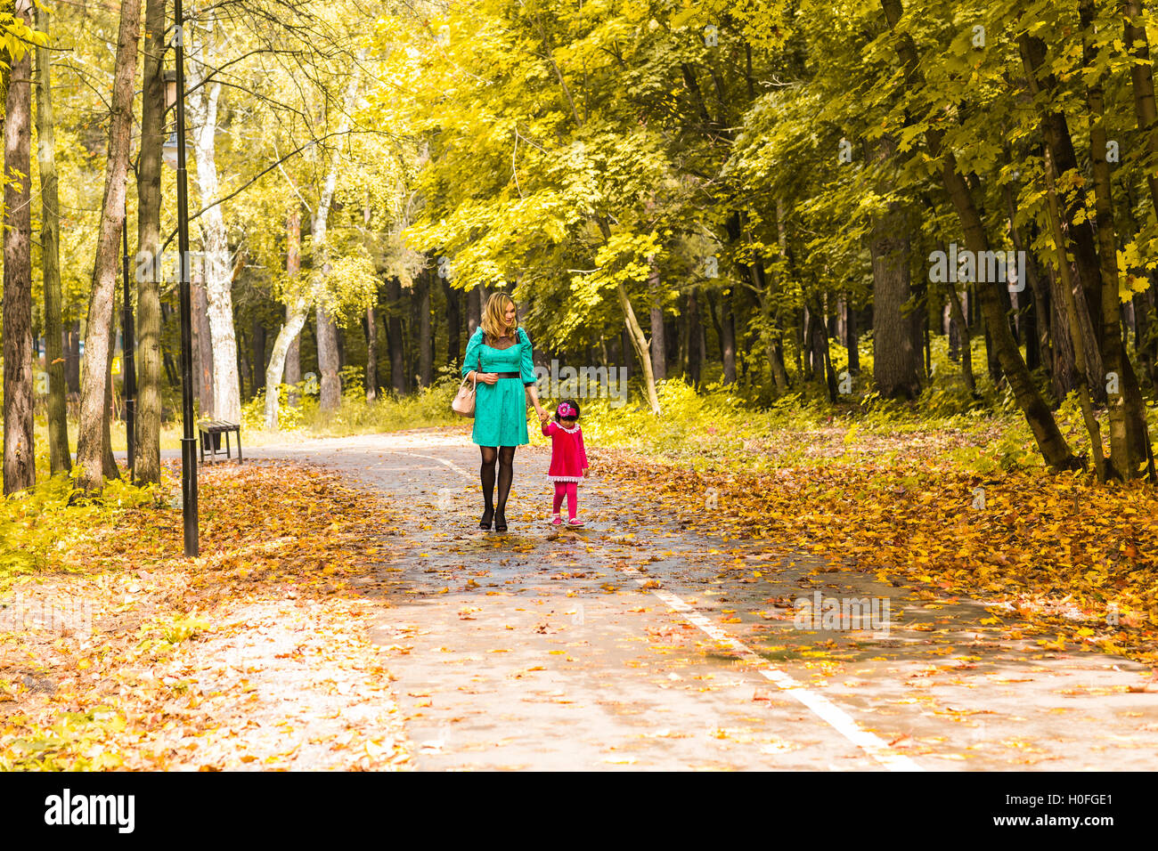 Mother with her baby. Mom and daughter in an autumn park Stock Photo ...
