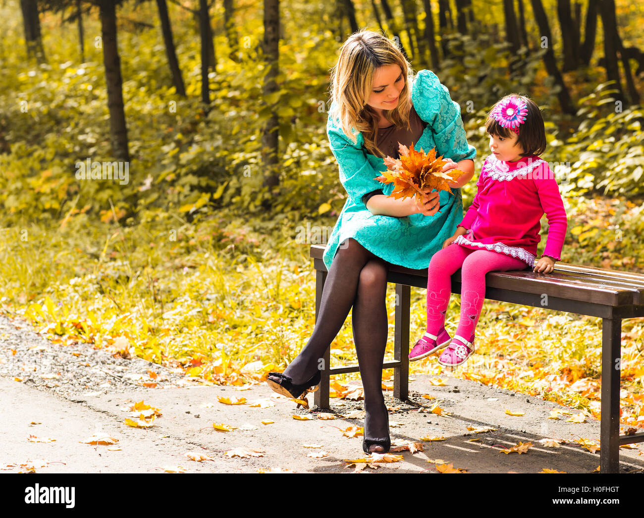 Little girl and her mother playing in the autumn park Stock Photo - Alamy
