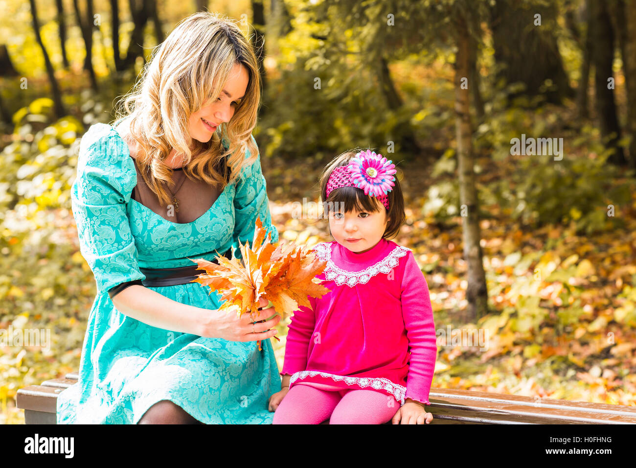 Young mother and her toddler girl have fun in autumn Stock Photo - Alamy