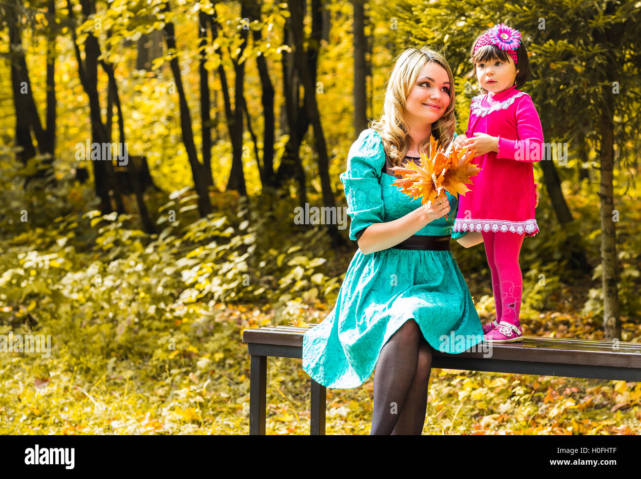 Little girl and her mother playing in the autumn park Stock Photo - Alamy