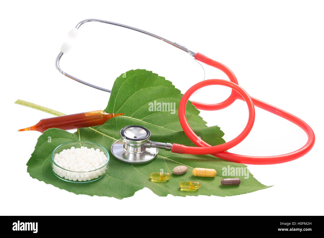 Alternative medicine herbs and stethoscope on leaf Stock Photo