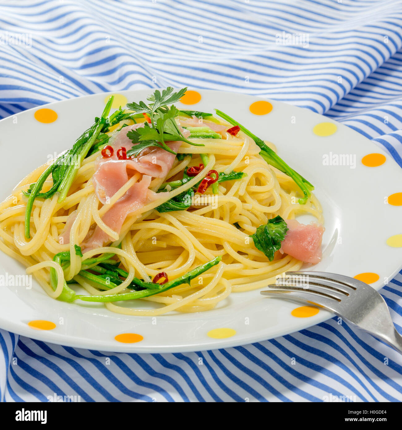 Pasta noodle with sauteed pork and vegetables on the tablecloth Stock Photo